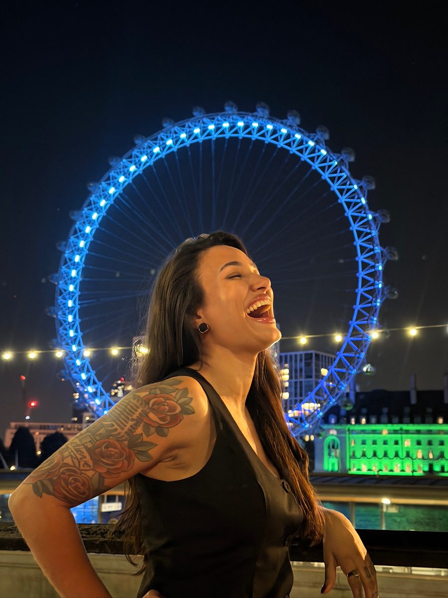 Gaba rindo em frente à London Eye, à noite
